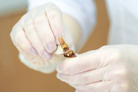 Close up of an ampoule opening process by hands with gloves