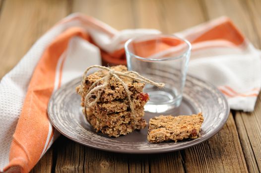 Granola bars with empty glass on wooden background horizontal