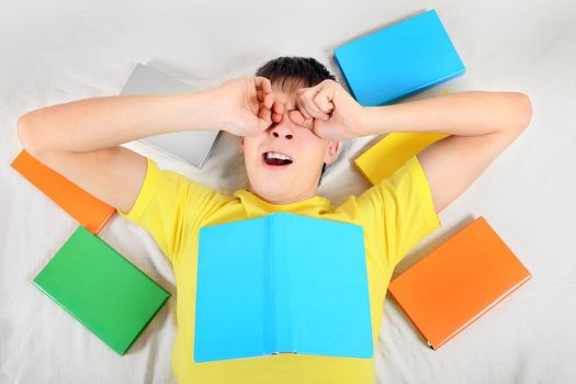 Tired Teenager Yawn with a Books on the Bed