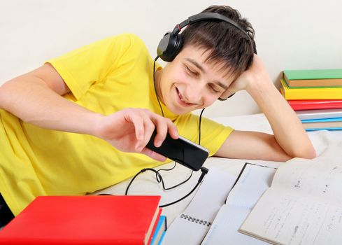 Cheerful Student listen the Music with the Books on the Bed