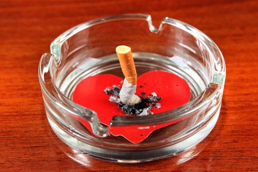 Cigarette in Ashtray with Heart Shape on the Table