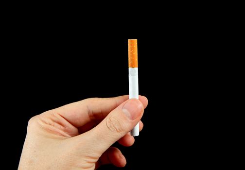 Cigarette in the Hand on the Black Background