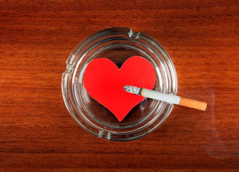 Cigarette in Ashtray with Heart Shape on the Table