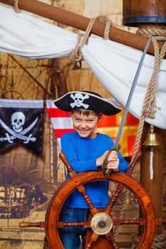 Cute little boy wearing pirate costume on the deck of a ship