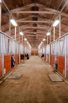 The center path through a horse barn light at the end of the tunnel