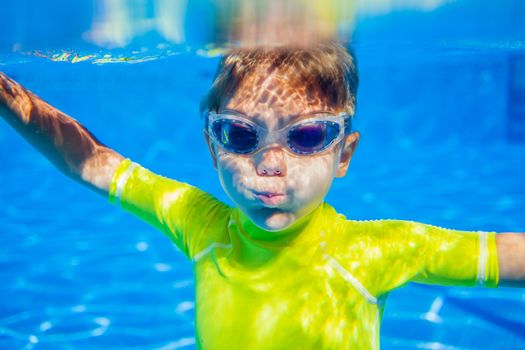 Closeup portrait of Underwater happy little boy in swimming pool