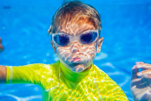 Closeup portrait of Underwater happy little boy in swimming pool