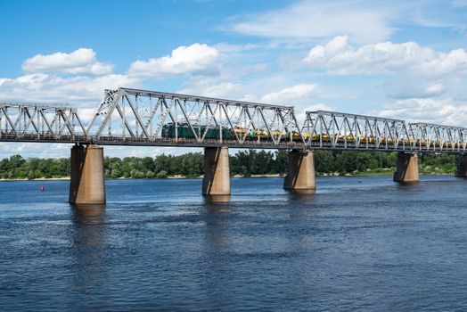 Petrivskiy railroad bridge in Kyiv across the Dnieper with freight train on it.