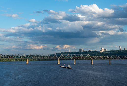 The barge floating in the blue Dnieper waters against the summer Kyiv landscape.