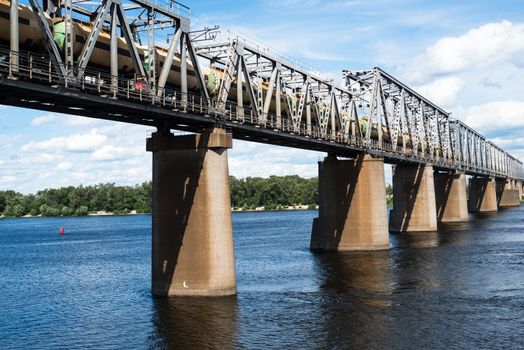 Petrivskiy railroad bridge in Kyiv across the Dnieper with freight train on it.