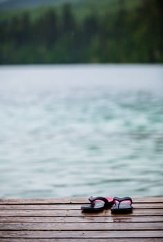 Flip flops on a Dock in front of a Turquoise Water Lake in the Wild Nature