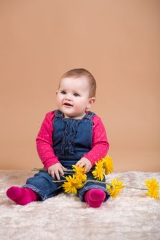 smiling infant baby with yellow flowers - the first year of the new life