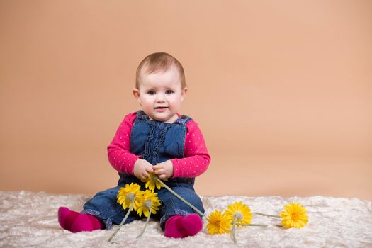 smiling infant baby with yellow flowers - the first year of the new life