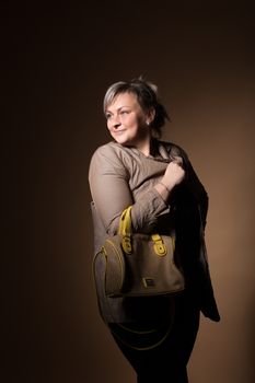 portrait of beautiful smiling plus size young blond woman posing with designer handbags