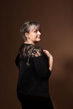 portrait of beautiful smiling plus size young blond woman posing with designer handbags and black dress