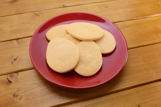 Egg shaped biscuits for Easter on a red plate on a wooden table