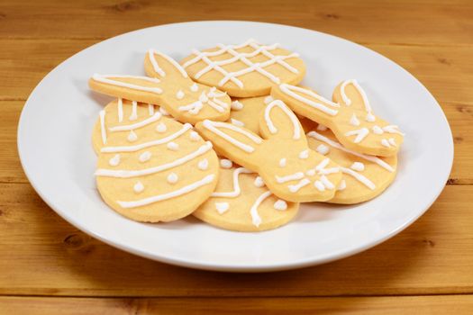 Plate of Easter cookies - eggs and bunnies - on a wooden table