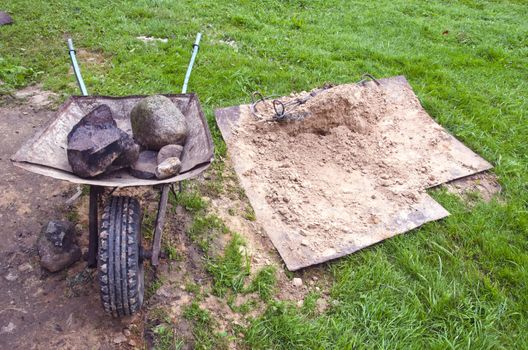 building work place with barrow and stone in farm