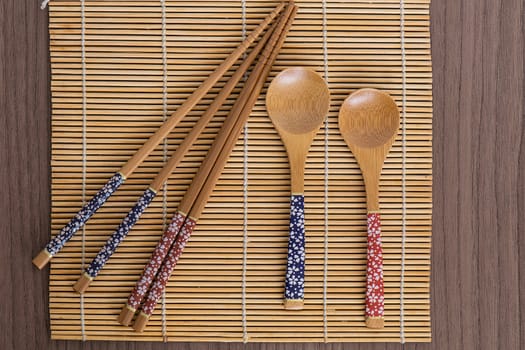 Some bamboo sushi tools over a bamboo mat 