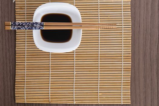 Blue decorated chopsticks over a soy sauce dish 