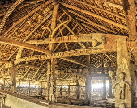 Interior of a traditional wooden dwelling with carved symbols in India