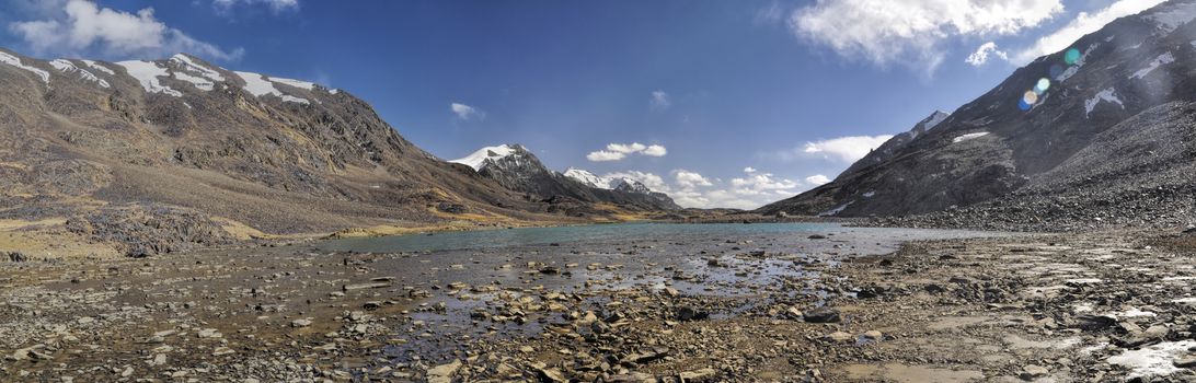 Scenic panorama of lake on arid landscape in Tajikistan on sunny day
