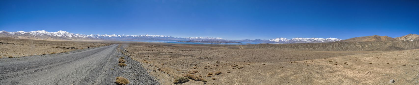 Scenic panorama of road leading through arid landscape in Tajikistan