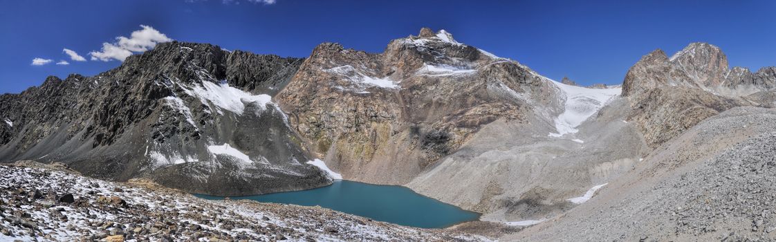 Scenic panorama of lake below highest mountain peaks in Ala Archa national park in Tian Shan mountain range in Kyrgyzstan