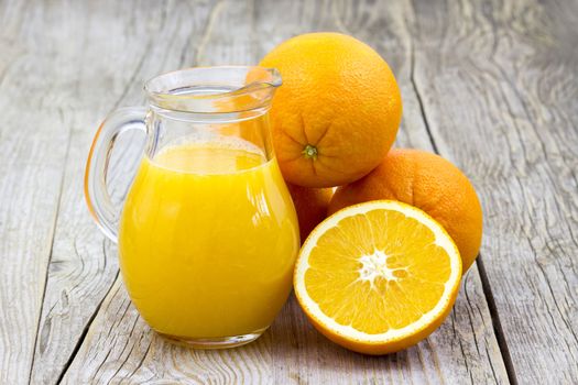 orange juice and fresh fruits on wooden background