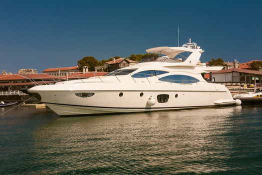 Row of luxury motorised yachts moored in a sheltered harbour, close up view of the bows