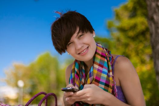 Young beautiful woman writes an SMS to your mobile phone
