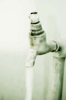 Tap of running water isolated on grey background