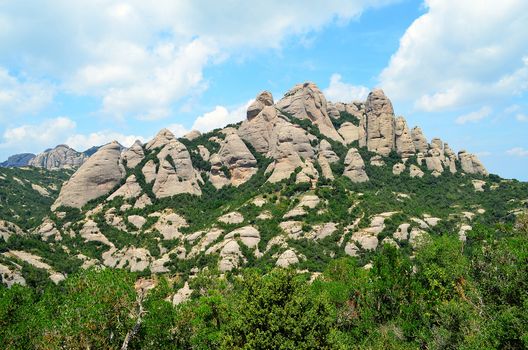 Montserrat is a multi-peaked mountain located near the city of Barcelona, in Catalonia.  "Montserrat" literally means "saw mountain" in Catalan.