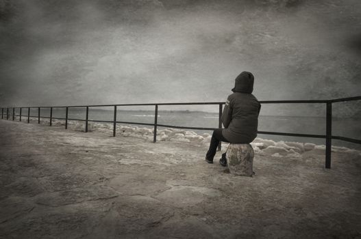 Creative textured image of person sitting by the water.