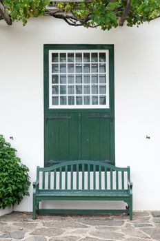 Bench and window with barn doors at the Drosdy, a historic building in Swellendam in the Western Cape Province of South Africa

