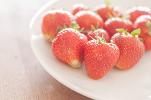 Fresh strawberries on white plate, stock photo
