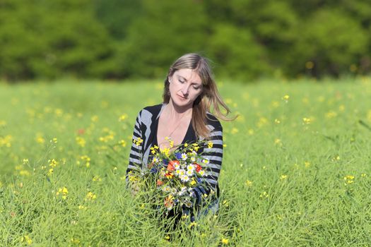 Woman Picking Wild Flowers on the Meadow in Spring