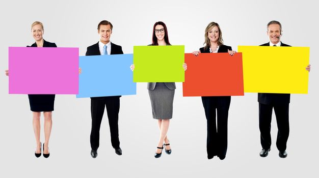 Business people posing with blank colorful boards