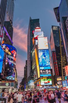 New York - Sept 2014: The glamorous streets of Times Square New York with thousands of tourists and residents are lit with giant screens displaying colorful advertisements on Sept 7, 2014 in New York, USA.