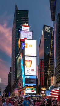 New York - Sept 2014: The glamorous streets of Times Square New York with thousands of tourists and residents are lit with giant screens displaying colorful advertisements on Sept 7, 2014 in New York, USA.