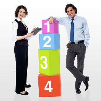 Business people posing beside number blocks