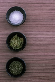 Three small containers with salt thyme and laurel