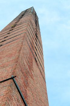Large chimney, chimney brick against a blue sky.