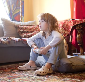 Boy Playing Console Game Sitting on the Floor