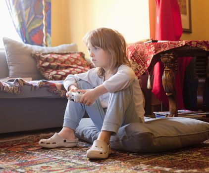 Boy Playing Console Game Sitting on the Floor