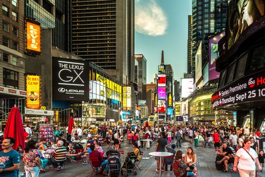 New York – Sept 2014: Tourists relax and enjoy the view of the busy streets of 42nd Street, Times Square on Sept 7, 2014 in New York, USA.