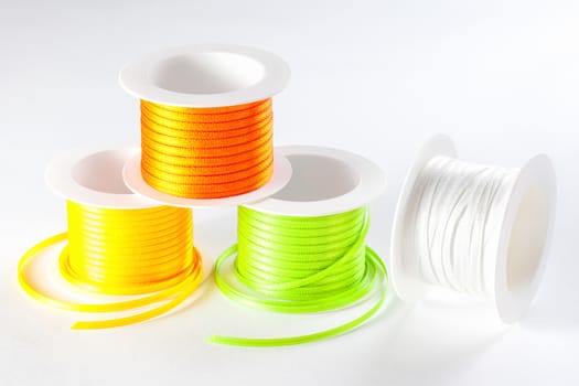 four spools of ribbon on white background