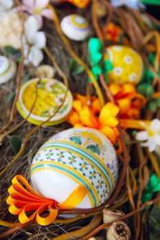 Easter composition with eggs, bird, ribbons and flowers in nest