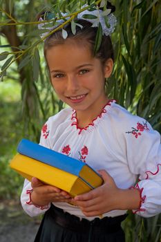 Beautiful little girl 7 years in embroidery books in color Ukrainian flag