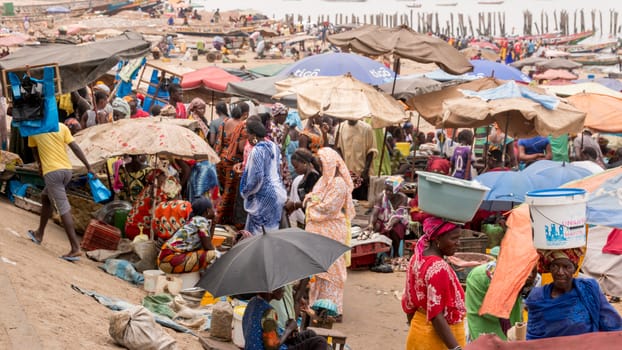 Mbour, Senegal - July, 2014: Several hundred people come together at the local fish market in Mbour to buy and sell the daily catch from the fishermen on July 9, 2014 in Mbour, Senegal.